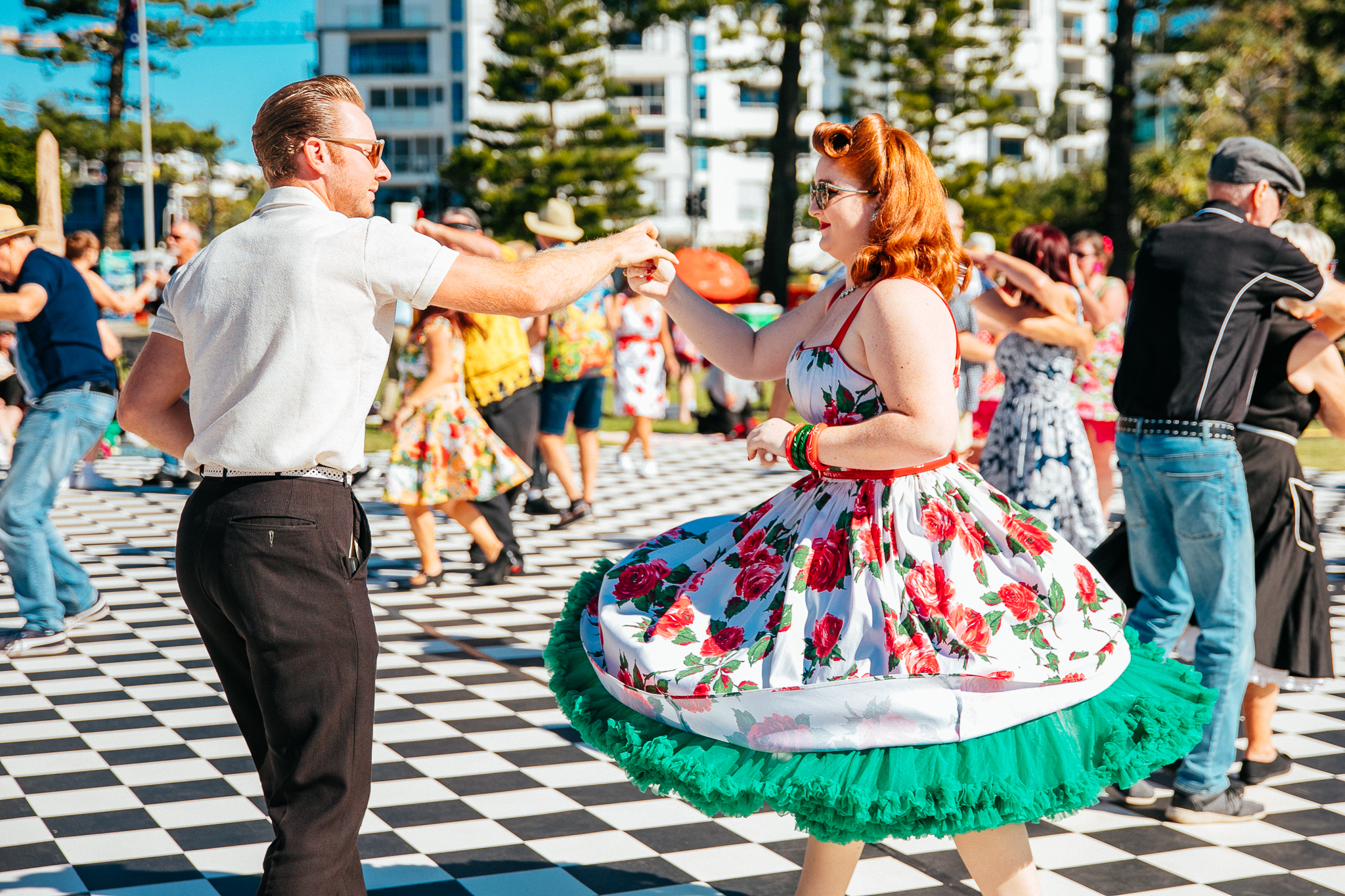 Swing dancers dressed in 50s clothes dance at a music festival